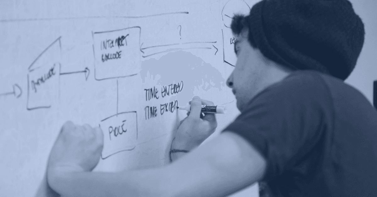 Developer drawing a software architecture flow diagram on a whiteboard — technical decision-making for build vs buy software strategy