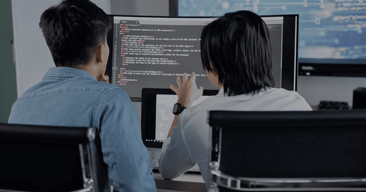 Software development team reviewing statistics and growth charts on monitors