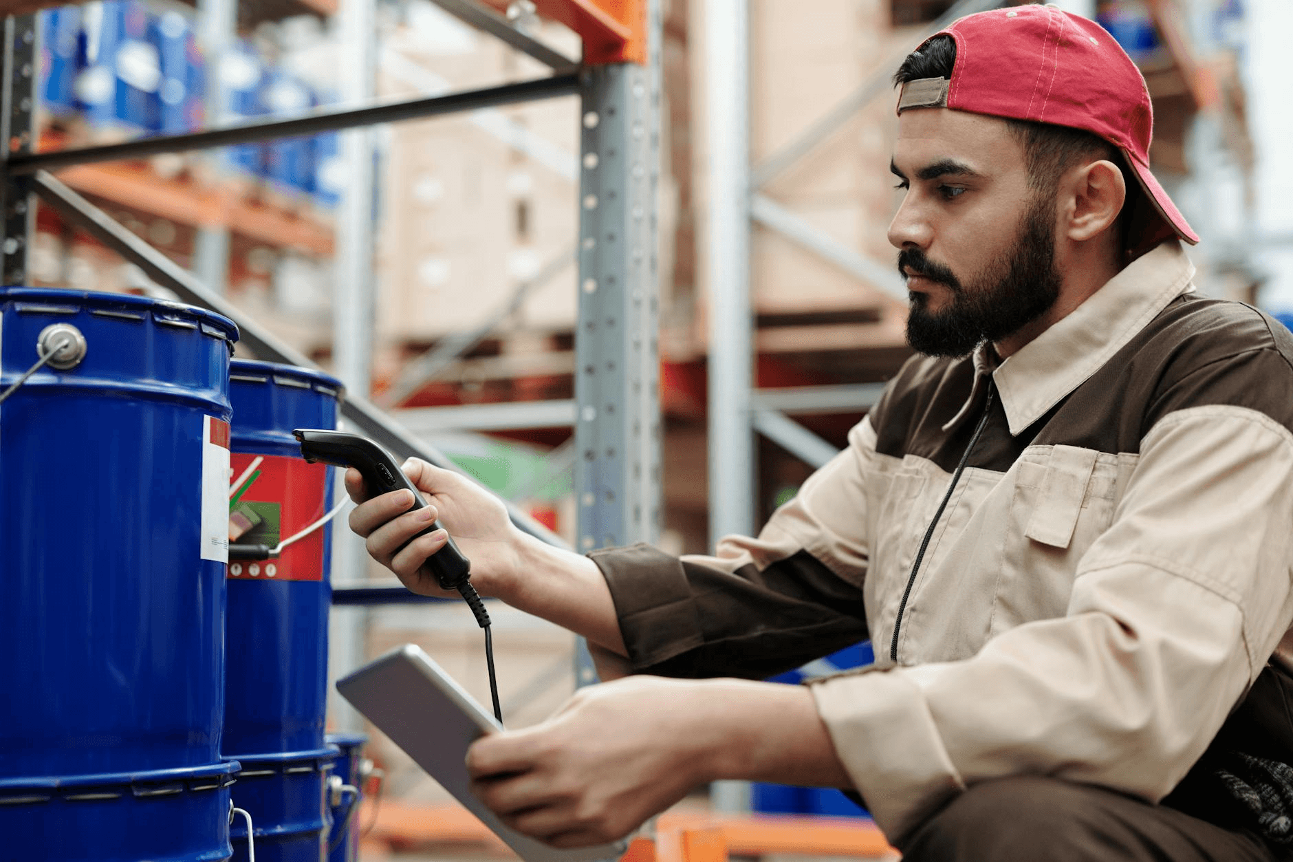 Maintenance technician using a tablet to scan a QR code on industrial equipment in a factory